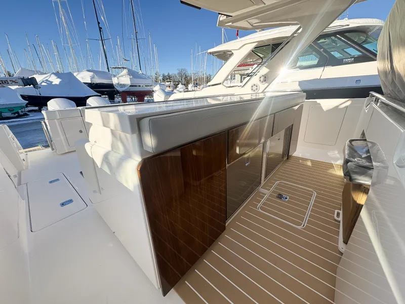 Slide: The Image of 2025 Tiara Yachts 43 LS interior with sleek design and wooden cabinetry in a marina setting. - 14