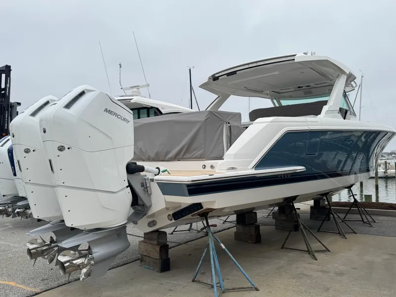 Slide: The Image of 2025 Tiara Yachts 43 LS with dual Mercury outboard engines, docked at a marina. - 2