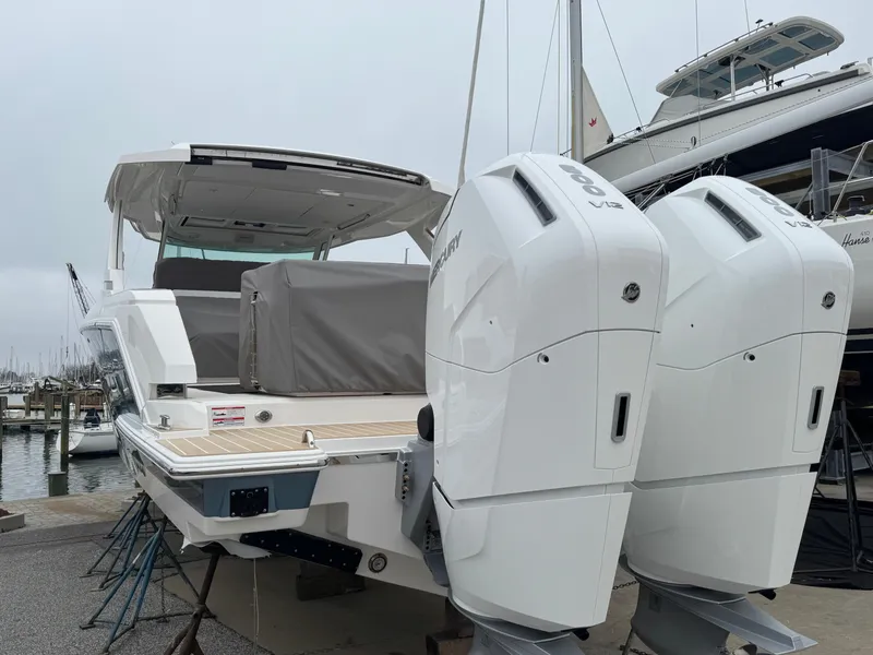 Slide: The Image of 2025 Tiara Yachts 43 LS with dual outboard engines at a marina. - 3