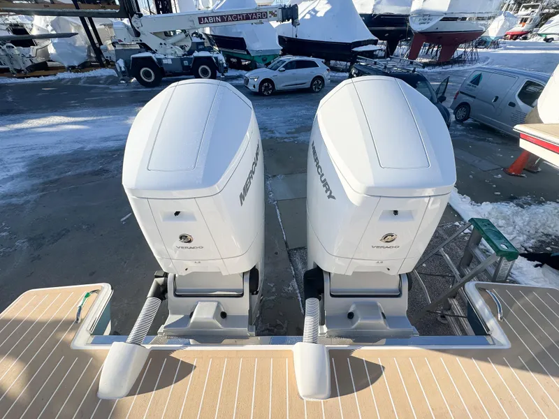 Slide: The Image of Twin Mercury outboard engines on a 2025 Tiara Yachts 43 LS, docked in a snowy marina. - 4