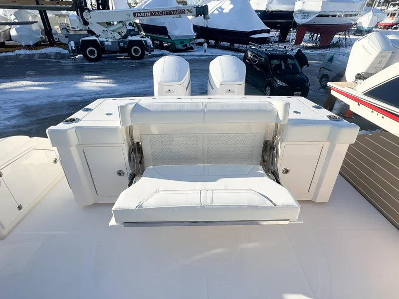 Slide: The Image of 2025 Tiara Yachts 43 LS boat with white seating and dual engines in a marina. - 6