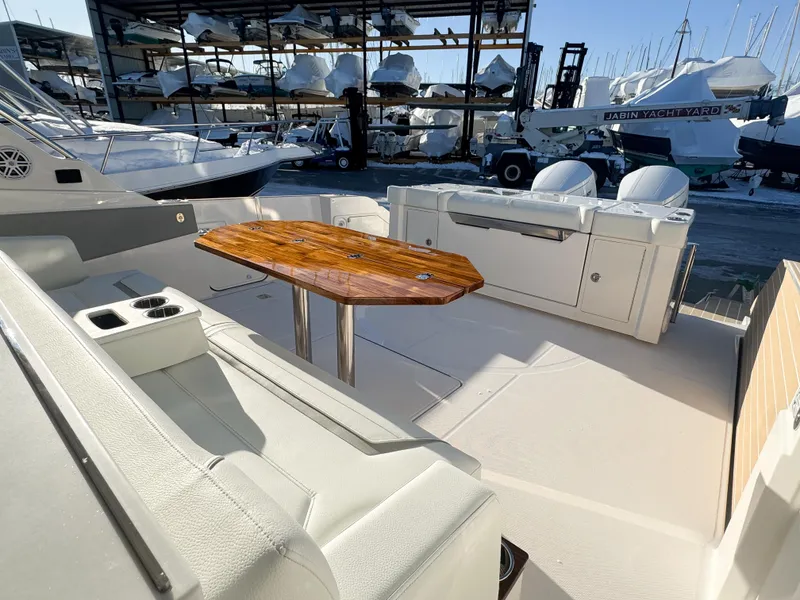 Slide: The Image of 2025 Tiara Yachts 43 LS interior with wooden table and seating, docked at marina. - 8
