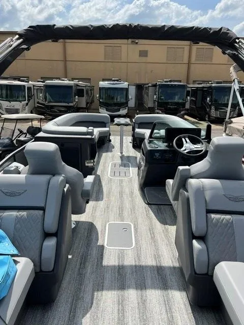 Slide: The Image of 2025 Bennington 26 MFB pontoon boat with luxurious seating and modern dashboard, parked near RVs. - 8