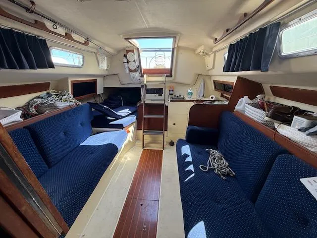 Slide: The Image of Interior of 1983 Pearson 303 sailboat with blue seating and wooden accents. - 31