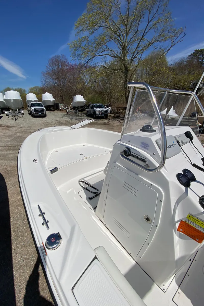 Slide: The Image of 2020 Edgewater 188CC boat with console, parked outdoors under clear blue sky. - 11