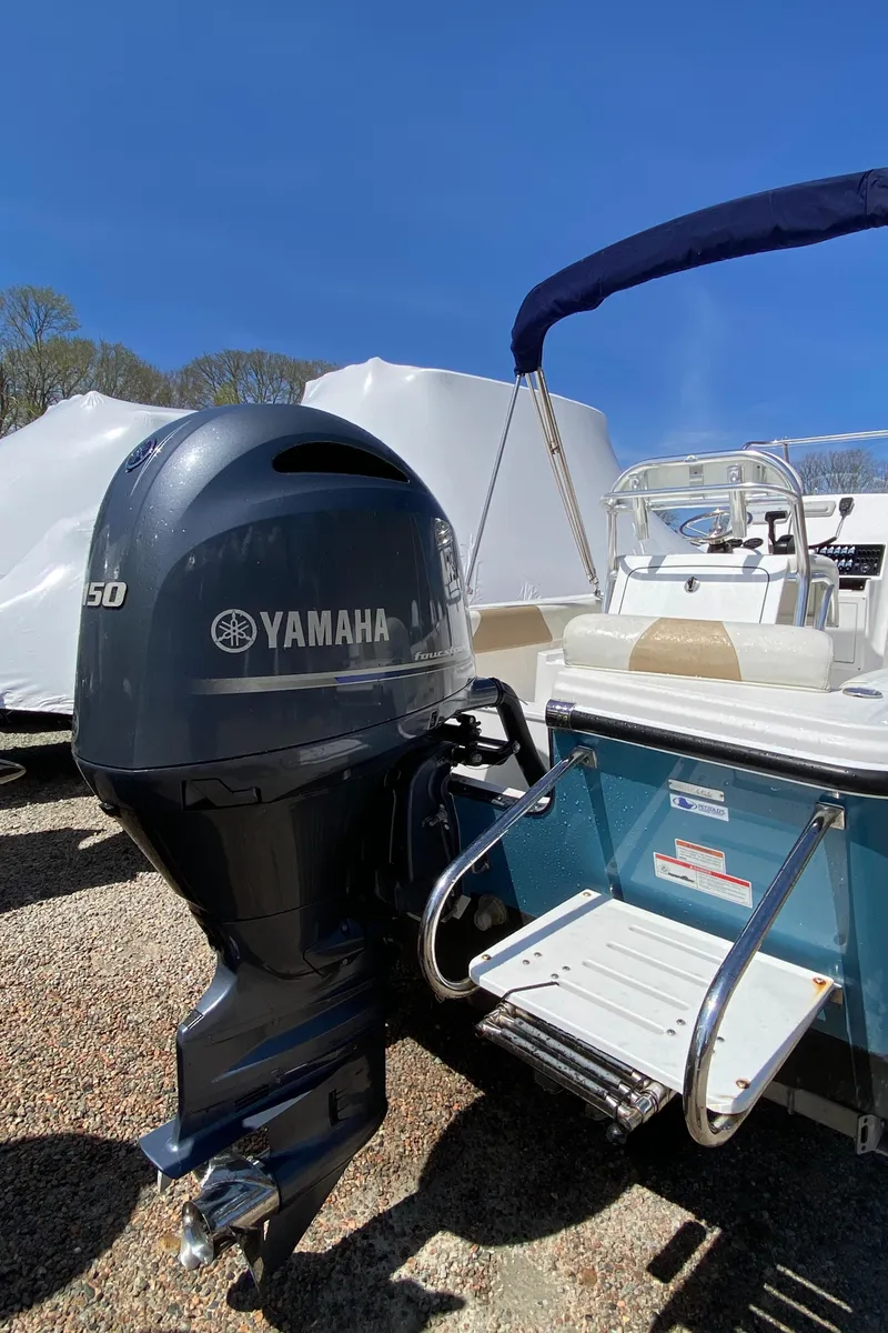 Slide: The Image of 2020 Edgewater 188CC boat with Yamaha outboard motor, docked under clear blue sky. - 20