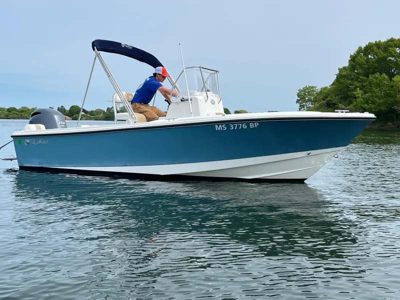 Slide: The Image of 2020 Edgewater 188CC boat on water with a person adjusting equipment. - 3