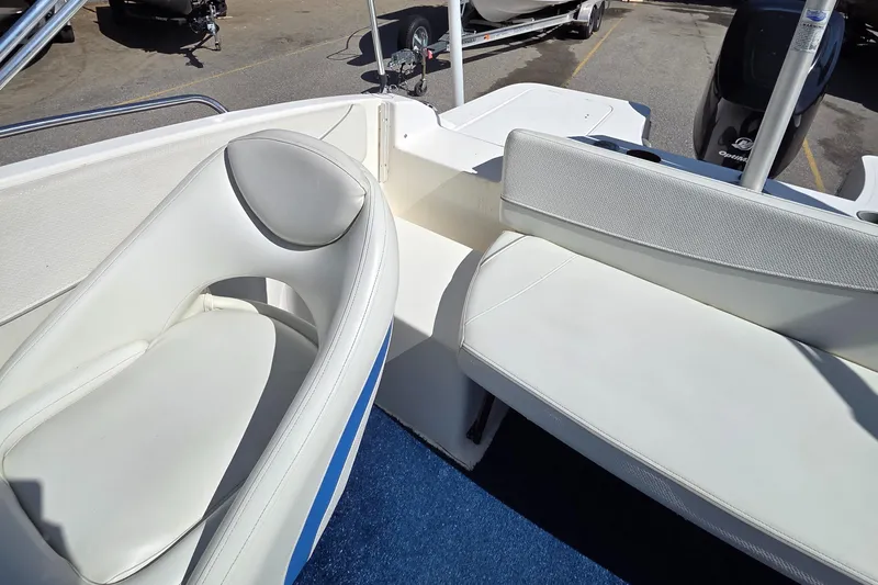 Slide: The Image of 2007 Bayliner 217 Deck Boat interior with white seating and blue carpet. - 11