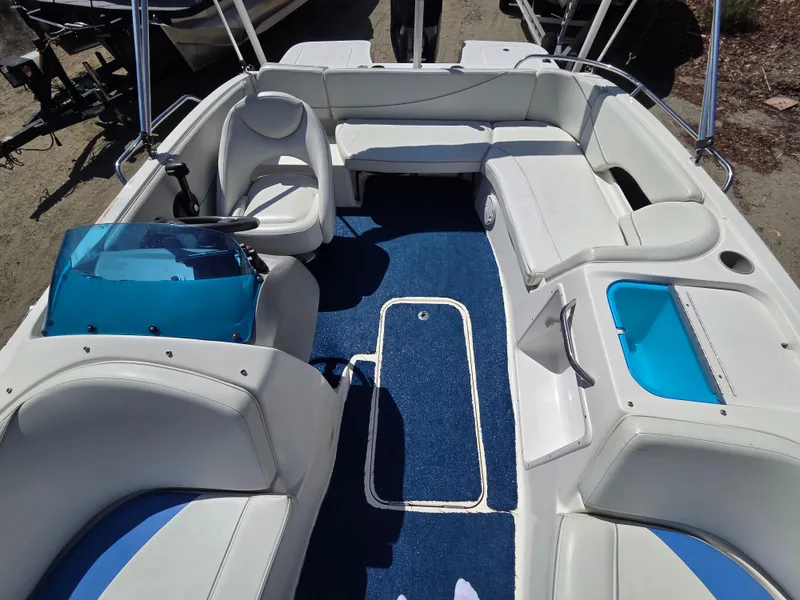 Slide: The Image of 2007 Bayliner 217 Deck Boat interior with blue carpet and white seating. - 13