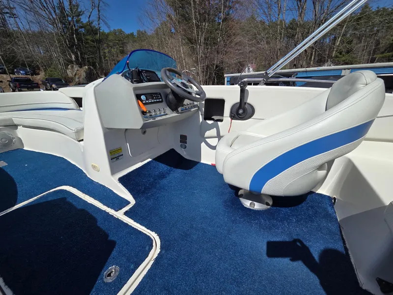 Slide: The Image of 2007 Bayliner 217 Deck Boat interior with blue carpet and white seating. - 15