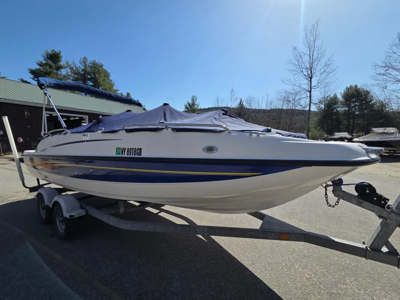 Slide: The Image of 2007 Bayliner 217 Deck Boat on trailer, covered, parked outdoors. - 2