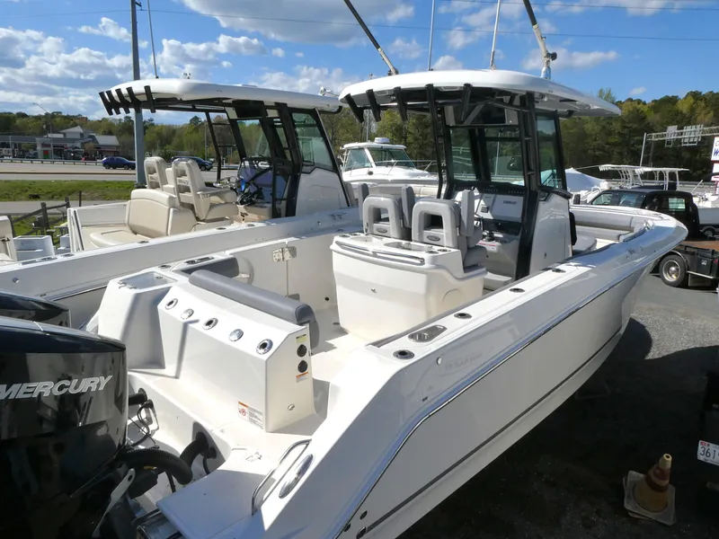 The Image of 2025 Boston Whaler 280 Outrage boat with dual consoles and spacious deck, docked outdoors. - 0