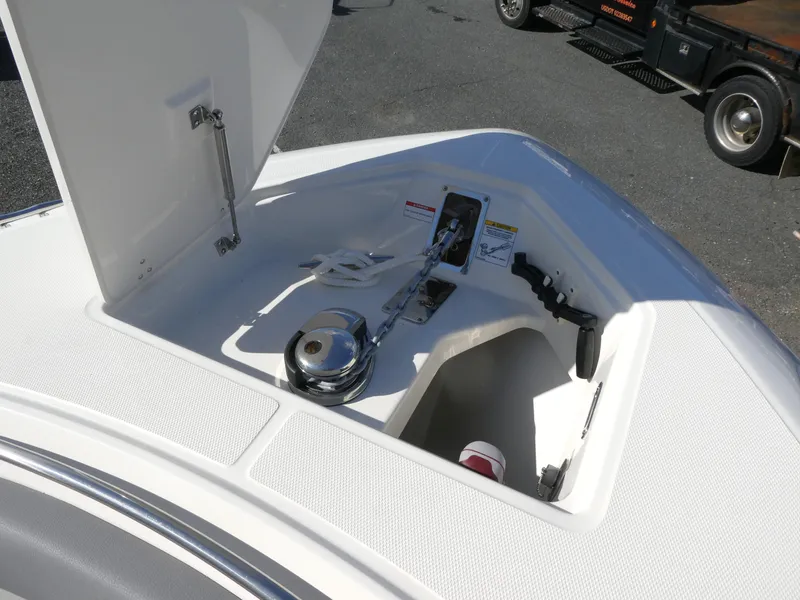 Slide: The Image of 2025 Boston Whaler 280 Outrage anchor compartment with open hatch and winch system. - 12