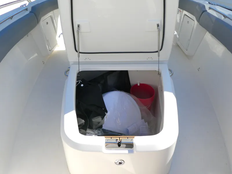 Slide: The Image of Open storage compartment on 2025 Boston Whaler 280 Outrage boat, containing various items. - 16