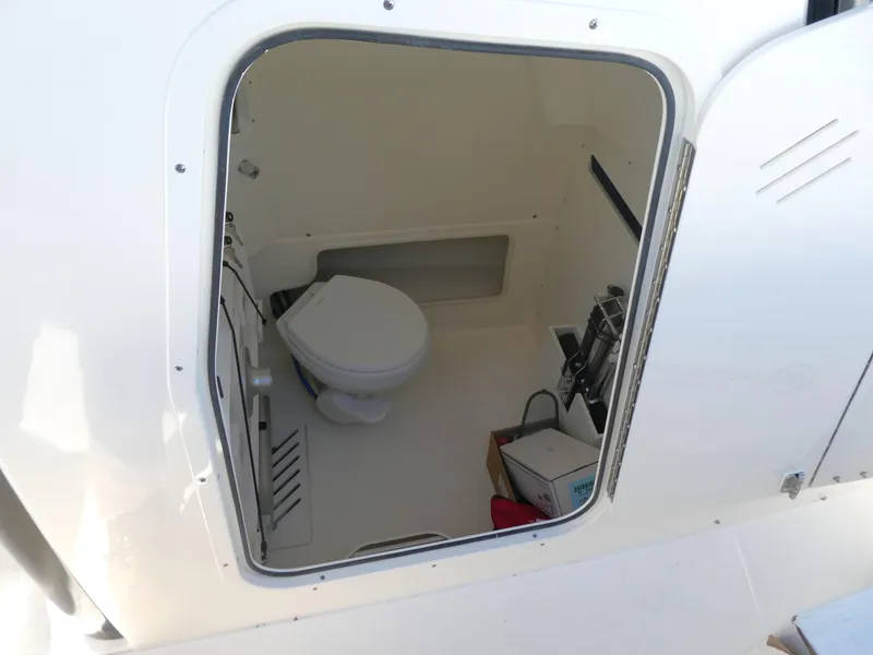 Slide: The Image of Boston Whaler 280 Outrage 2025 boat interior with compact marine toilet. - 17