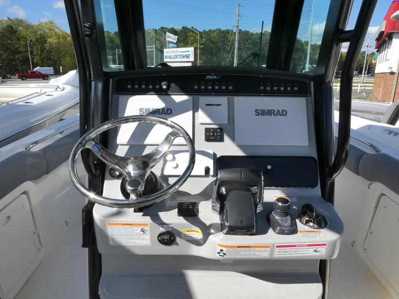 Slide: The Image of 2025 Boston Whaler 280 Outrage helm with Simrad electronics and steering wheel. - 7