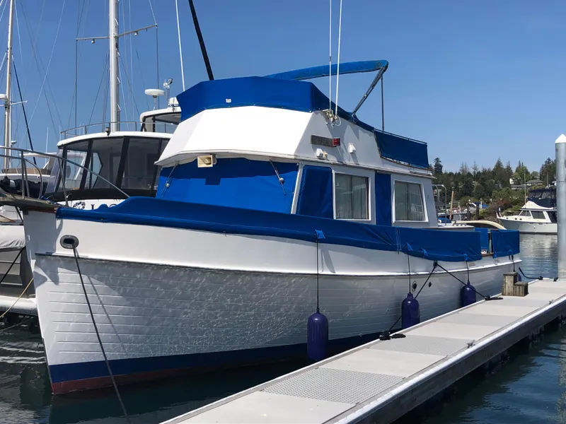 The Image of 1976 Grand Banks 42 Classic yacht docked at marina, featuring blue and white exterior. - 0