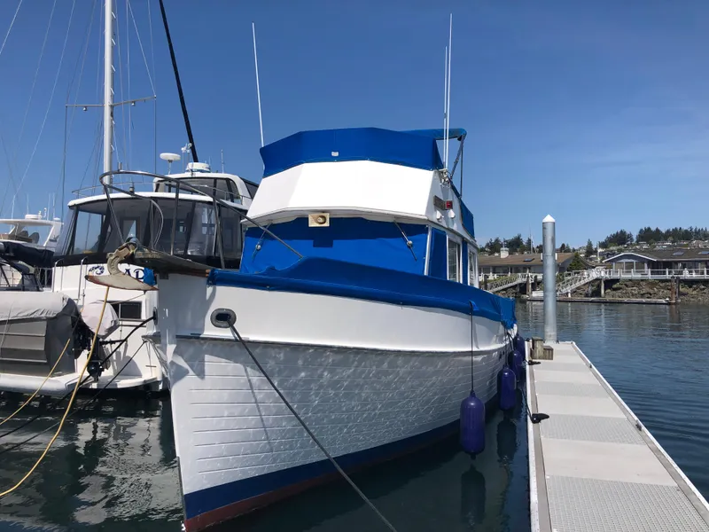 Slide: The Image of 1976 Grand Banks 42 Classic yacht docked at marina under clear blue sky. - 1