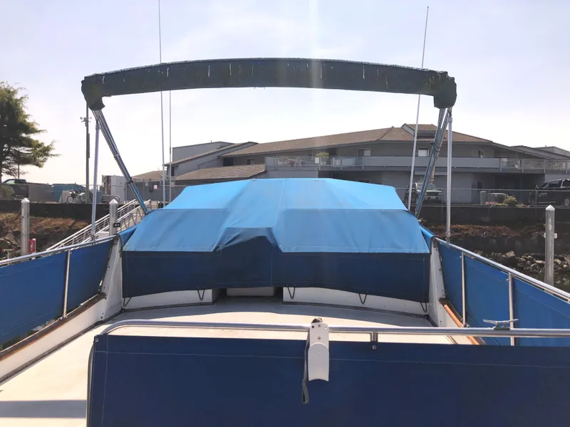 Slide: The Image of 1976 Grand Banks 42 Classic boat with blue covers docked at a marina. - 10