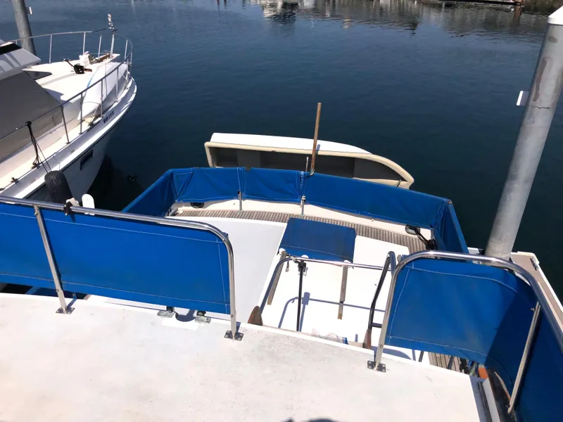 Slide: The Image of 1976 Grand Banks 42 Classic yacht with blue deck covers at a marina. - 11