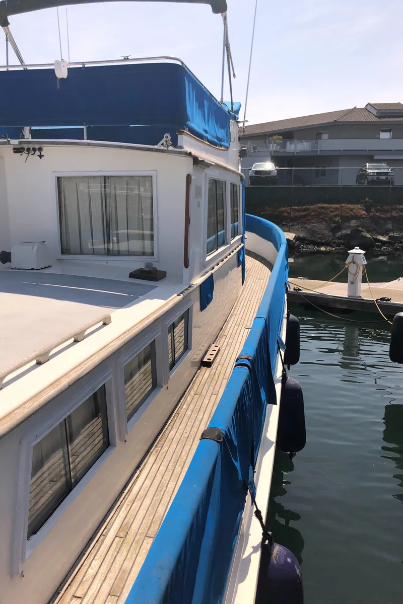 Slide: The Image of 1976 Grand Banks 42 Classic yacht docked, featuring blue accents and wooden deck. - 21