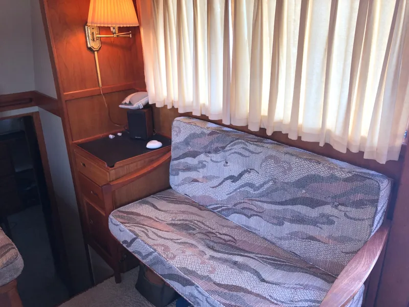 Slide: The Image of 1976 Grand Banks 42 Classic interior with patterned seating, wooden desk, and lamp. - 25