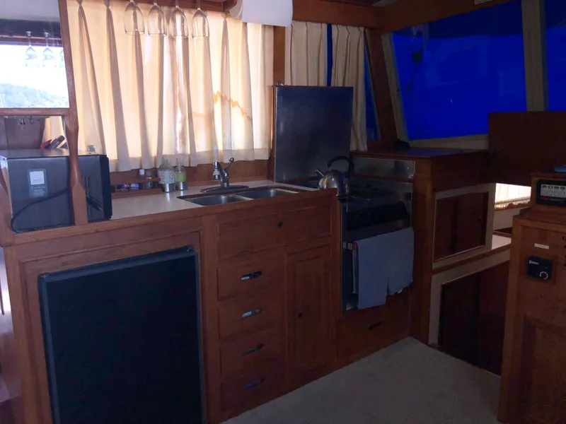 Slide: The Image of 1976 Grand Banks 42 Classic yacht interior with wooden cabinetry and kitchen amenities. - 28