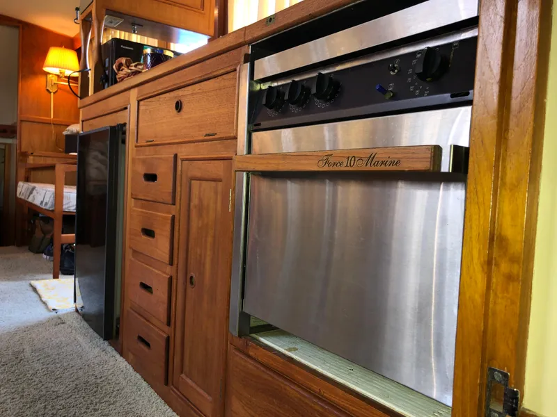 Slide: The Image of 1976 Grand Banks 42 Classic interior with wooden cabinetry and stainless steel appliances. - 29