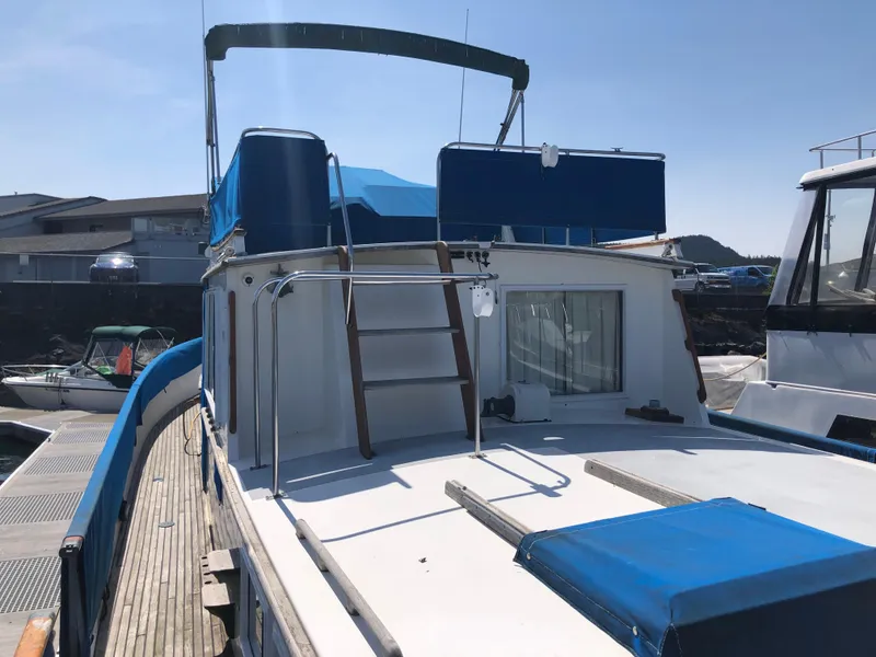 Slide: The Image of 1976 Grand Banks 42 Classic yacht with blue accents docked at a marina. - 3