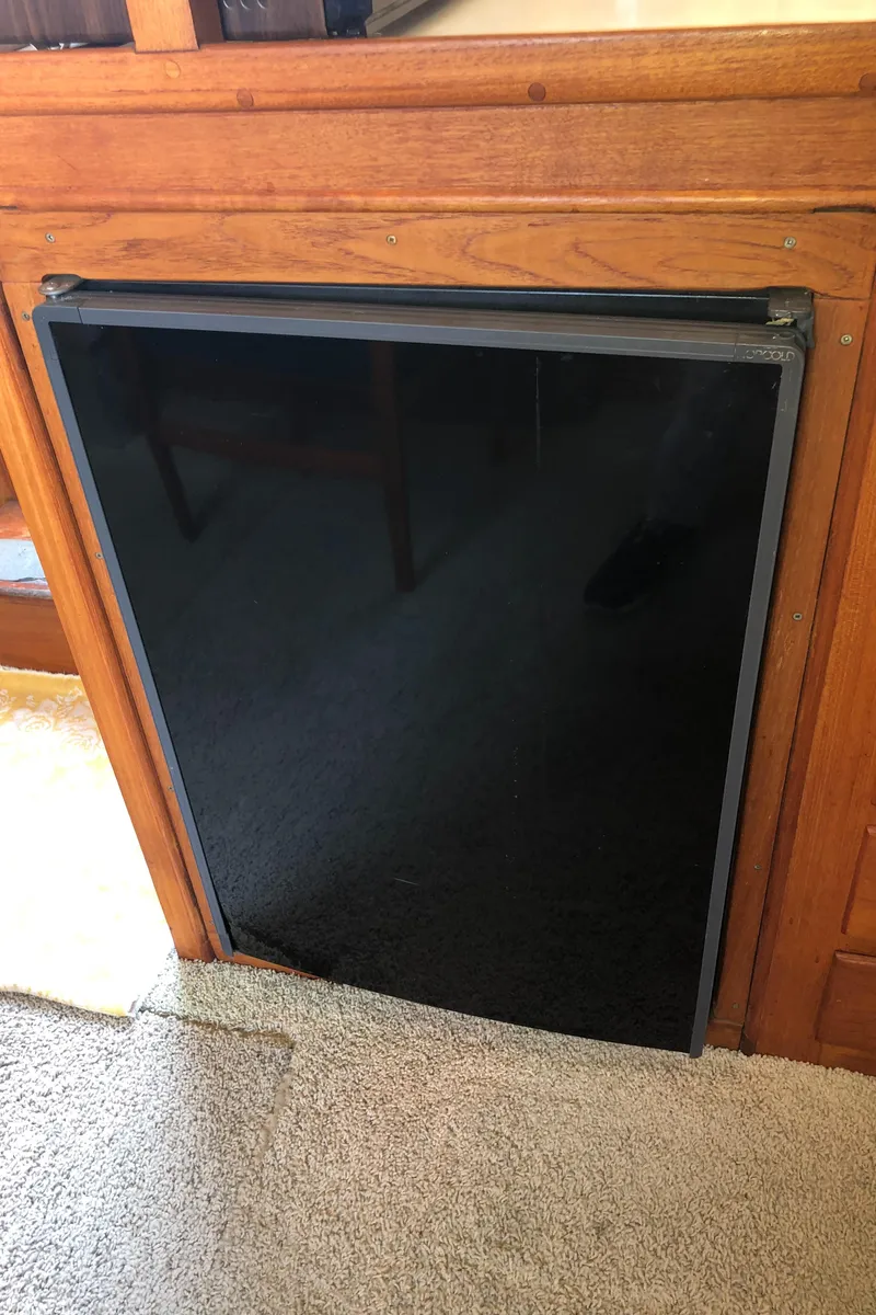 Slide: The Image of 1976 Grand Banks 42 Classic interior with a black panel appliance and wooden cabinetry. - 32