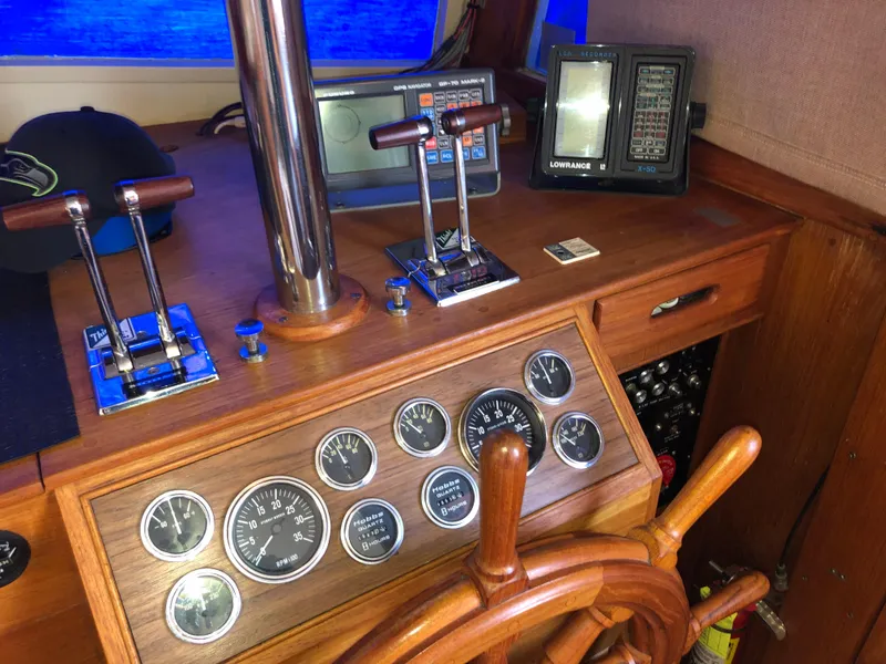 Slide: The Image of 1976 Grand Banks 42 Classic helm with wooden wheel, gauges, and navigation equipment. - 35