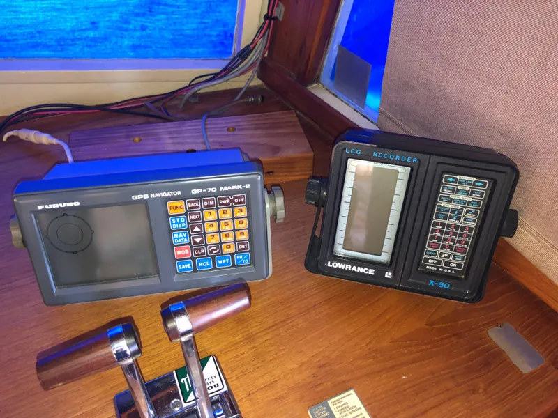 Slide: The Image of 1976 Grand Banks 42 Classic navigation equipment, featuring GPS and echo recorder on wooden dashboard. - 38