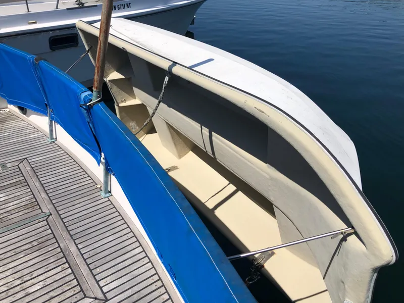 Slide: The Image of 1976 Grand Banks 42 Classic boat with blue railing, docked on calm water. - 6