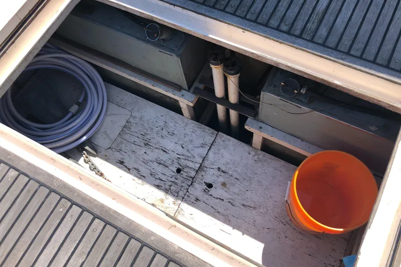 Slide: The Image of Open storage compartment on 1976 Grand Banks 42 Classic boat with hose and orange bucket. - 7