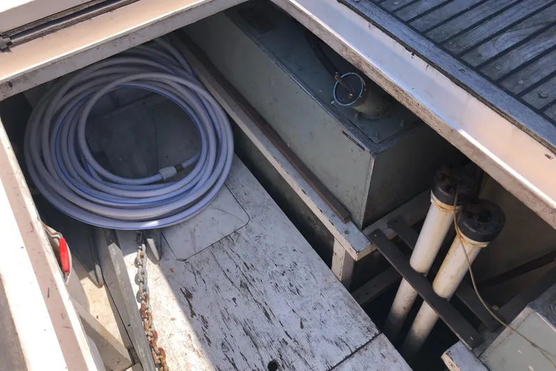 Slide: The Image of Storage compartment of a 1976 Grand Banks 42 Classic boat with coiled hose and equipment. - 9