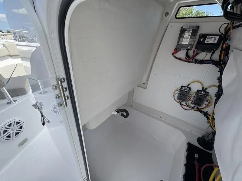 Slide: The Image of 2025 Sportsman Open 212 boat interior wiring and storage compartment. - 15