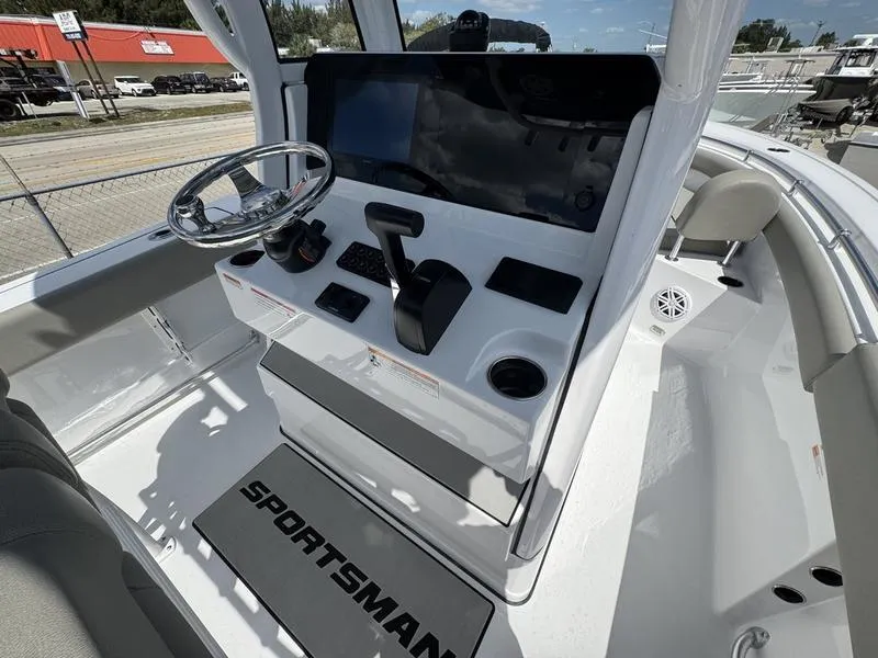 Slide: The Image of 2025 Sportsman Open 212 boat console with steering wheel and modern controls. - 22