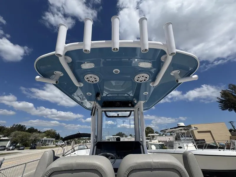 Slide: The Image of 2025 Sportsman Open 212 boat with rod holders and speakers under a blue sky. - 28