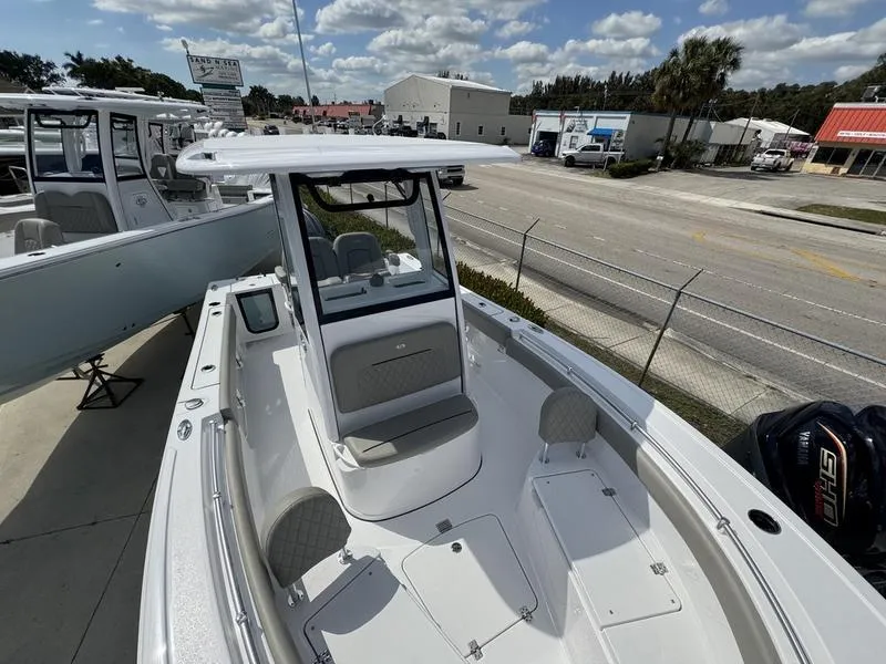Slide: The Image of 2025 Sportsman Open 212 boat with T-top, parked outdoors on a sunny day. - 8
