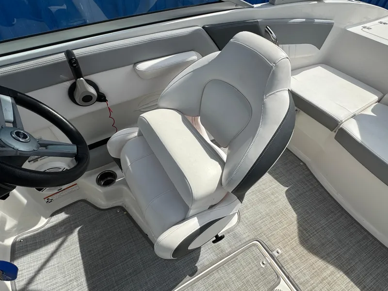 Slide: The Image of 2019 Chaparral 21 H2O Sport OB boat interior with steering wheel and seating. - 16