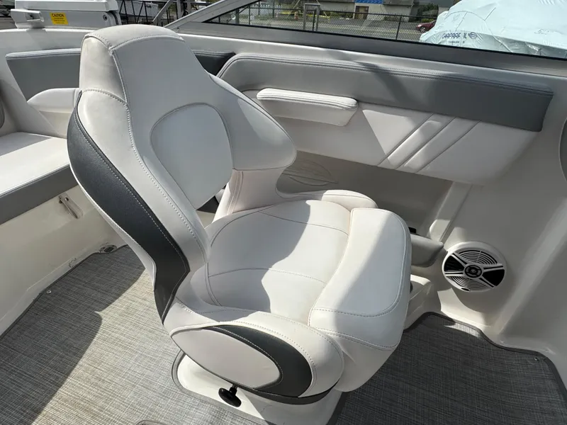Slide: The Image of 2019 Chaparral 21 H2O Sport OB boat interior with cushioned seating and speaker. - 24