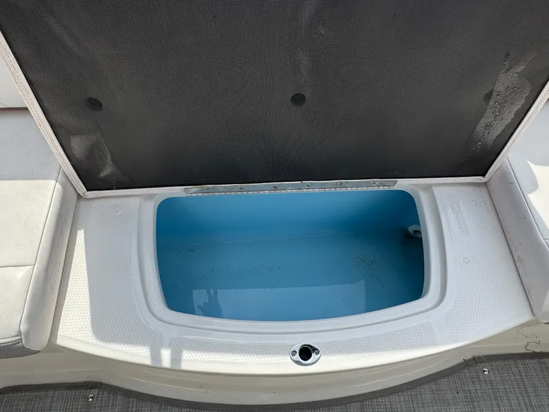 Slide: The Image of 2019 Chaparral 21 H2O Sport OB boat storage compartment open, showing interior. - 27