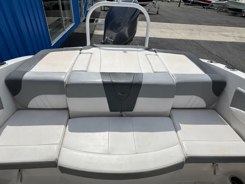 Slide: The Image of 2019 Chaparral 21 H2O Sport OB boat with cushioned seating and outboard motor. - 29