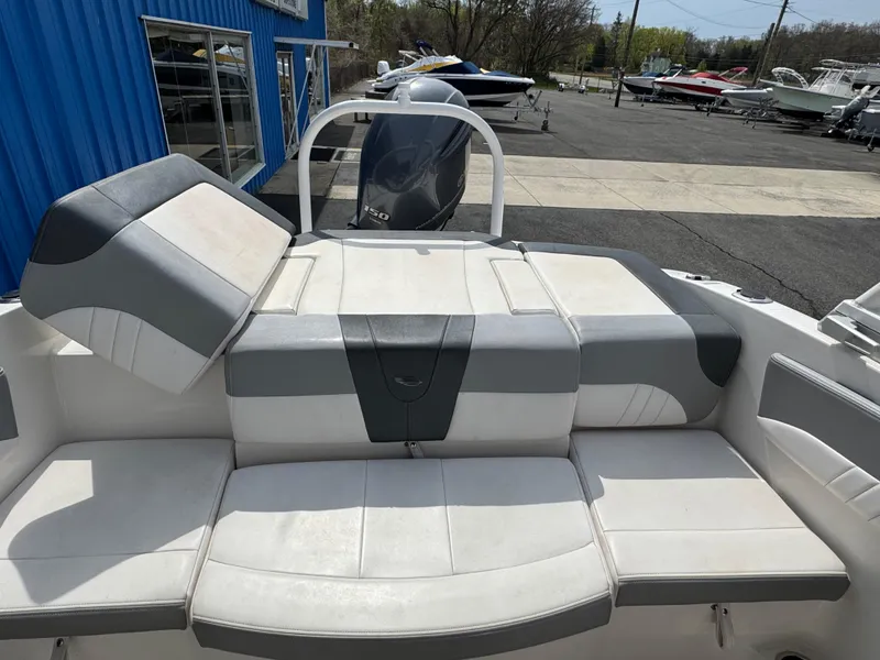 Slide: The Image of 2019 Chaparral 21 H2O Sport OB boat with cushioned seating and outboard motor. - 30