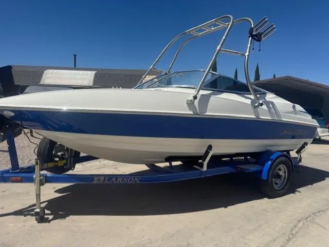 Slide: The Image of 2006 Larson 186 SENZA boat on trailer, blue and white design, parked outdoors. - 1