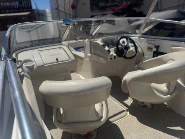 Slide: The Image of Interior of a 2006 Larson 186 SENZA boat, featuring white seating and steering console. - 10