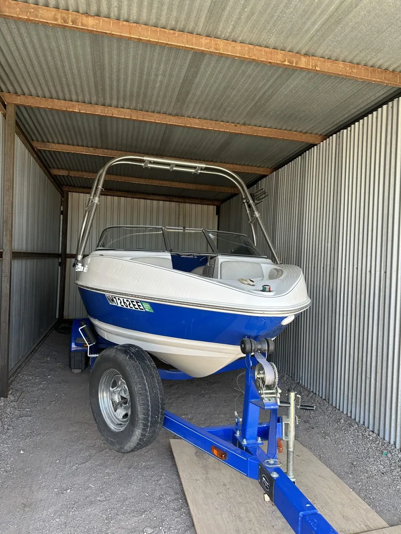 Slide: The Image of 2006 Larson 186 SENZA boat with trailer in a metal storage shed. - 15