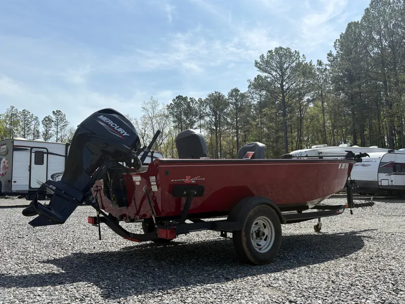 Slide: The Image of 2021 Tracker Super Guide V-16 T boat with Mercury engine, parked on gravel lot. - 4