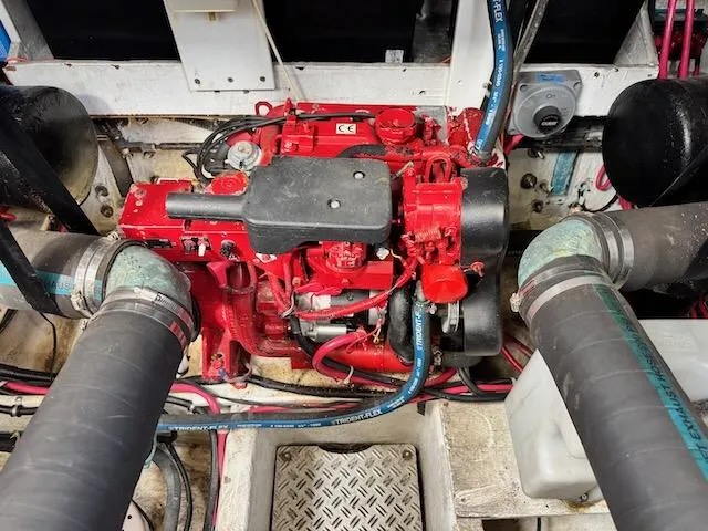 Slide: The Image of Engine compartment of a 2001 Maxum 3500 SCR boat, featuring a red engine and hoses. - 26