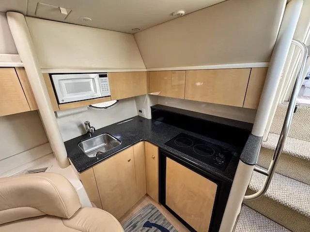 Slide: The Image of 2001 Maxum 3500 SCR yacht interior kitchen with microwave, sink, and stove. - 31